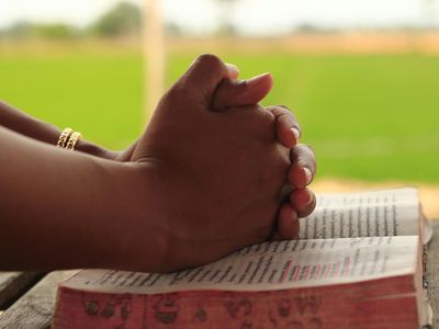 Close-up of a person's hands clasped together during a moment of focus.