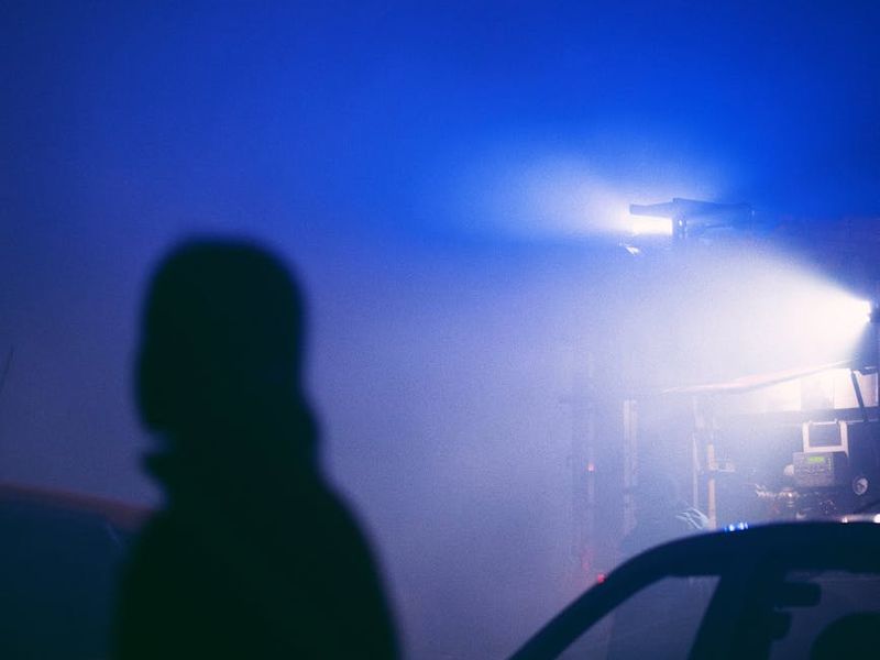 Silhouette of a person in a dynamic stretching pose against a dark background.